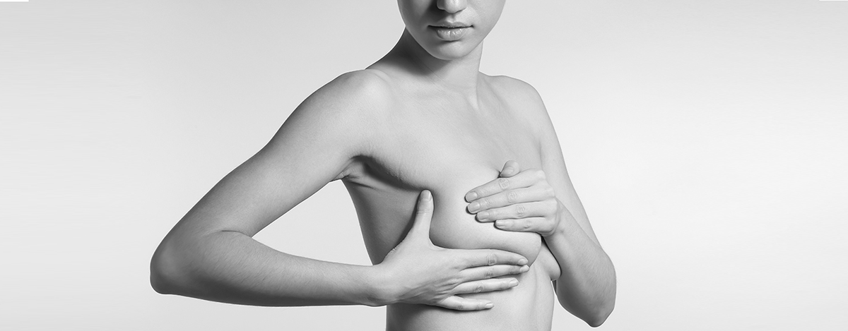 Young woman checking her breast on light background. Cancer awareness concept